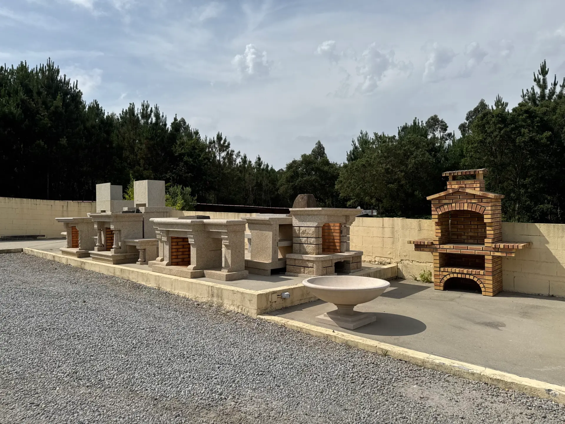 Exposição de churrasqueiras, fornos e fontes em pedra no espaço exterior das instalações da Granineiva.