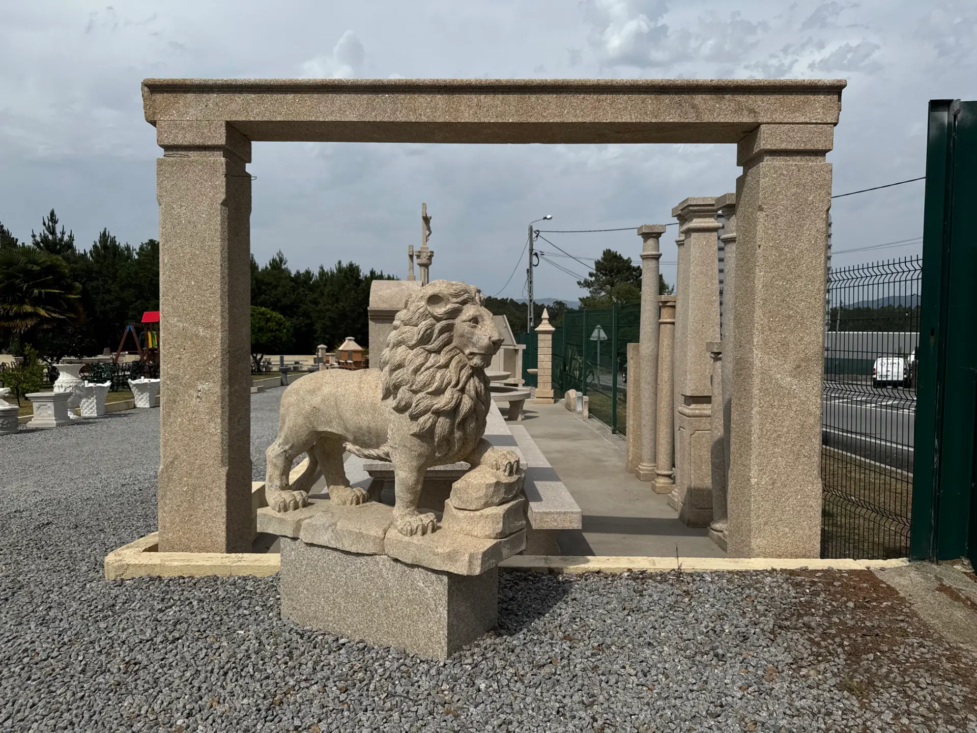 Escultura de leão em granito junto a um pórtico de cantaria, no espaço exterior da Granineiva.